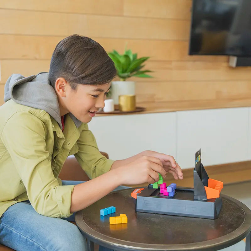 Enfant jouant avec Kanoodle Shape Escape, un puzzle logique 3D chronométré