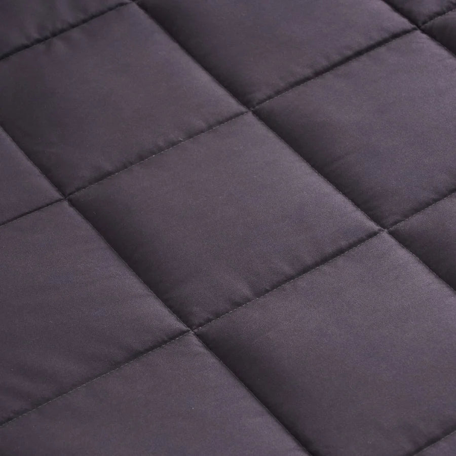 Gros plan sur le tissu en microfibre et les compartiments cousus de la couverture lestée Slumber gris anthracite.