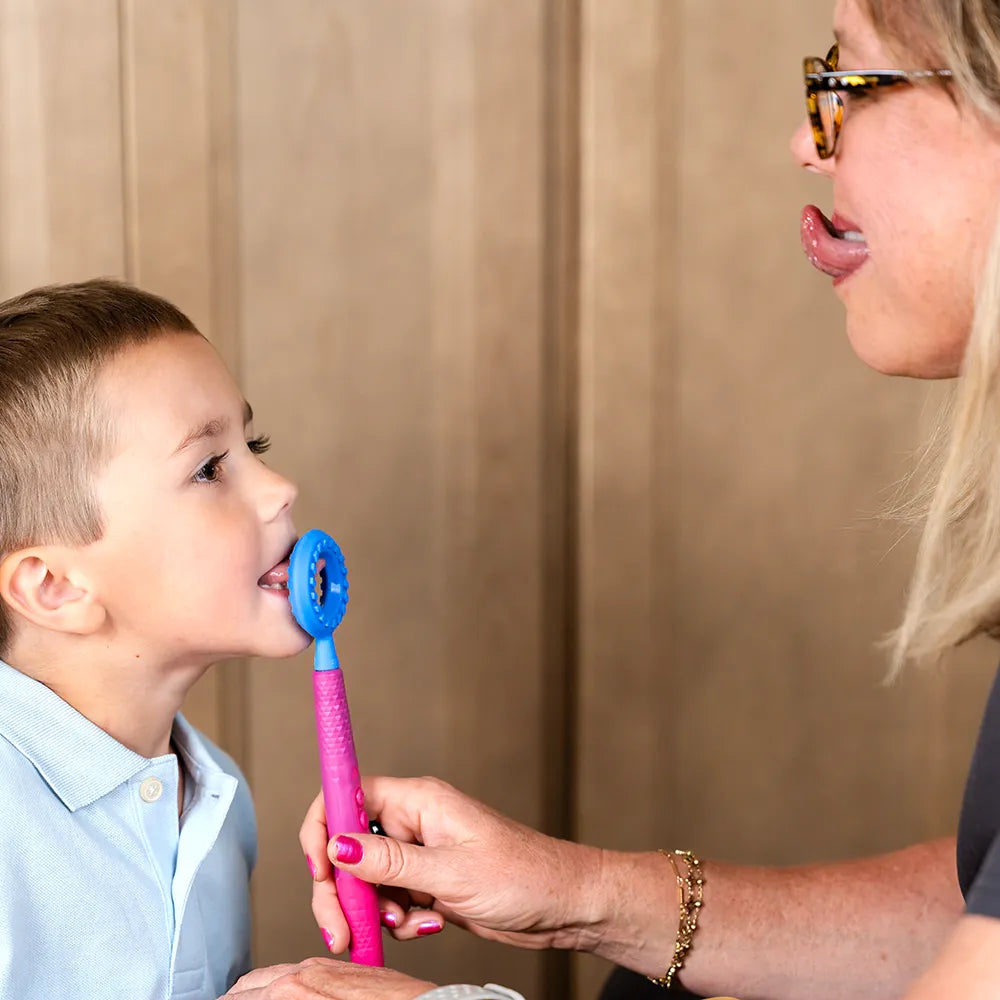 Utilisation de l’embout rond bleu ARK sur un Z‑Vibe pour stimuler les mouvements de la langue chez un enfant.