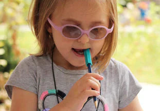 enfant qui mâche un embout de stylo