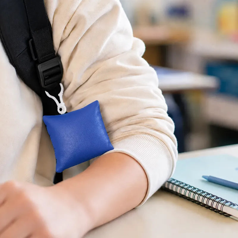 Mini coussin vibrant Senseez accroché à un sac à dos en salle de classe