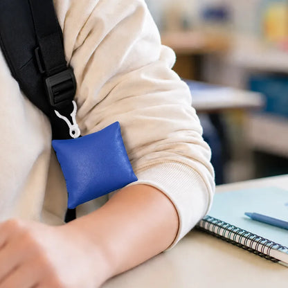 Mini coussin vibrant Senseez accroché à un sac à dos en salle de classe