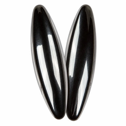 Deux pierres aimantées noires, lisses et brillantes, de forme allongée