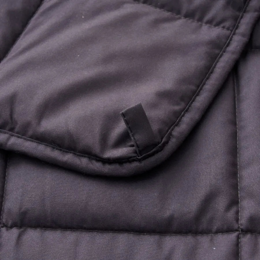 Détail des coutures et d’une boucle de fixation de la couverture lestée Slumber gris anthracite.
