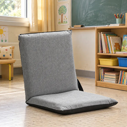Chaise de sol pliante grise installée dans une salle de classe.
