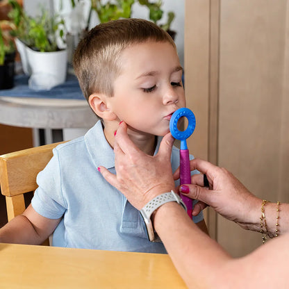 Utilisation de l’embout rond bleu ARK sur un Z‑Vibe pour stimuler le contour des lèvres chez un enfant.