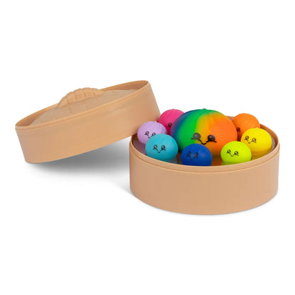 Squishies antistress colorés rangés dans leur panier vapeur, couvercle posé à côté