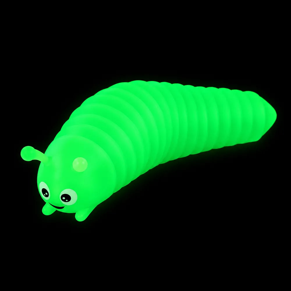 Limace articulée phosphorescente avec yeux et sourire, brillant en vert dans le noir.