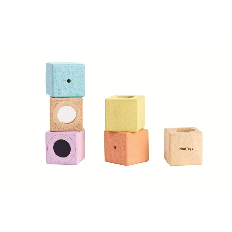 Blocs sensoriels PlanToys colorés empilés et emboîtés dans des cubes en bois naturel